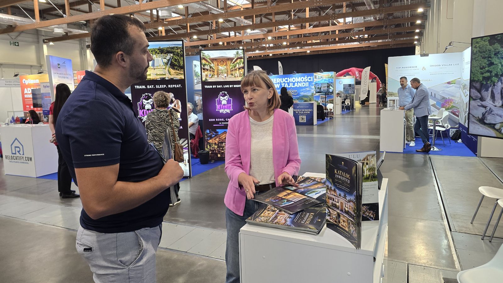 Rozmowa z odwiedzającym o inwestycjach w Tajlandii w hali EXPO Kraków